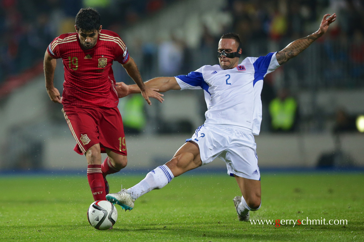 Maxime Chanot of Luxembourg tackles Diego Costa of Spain during EM Qualifying game