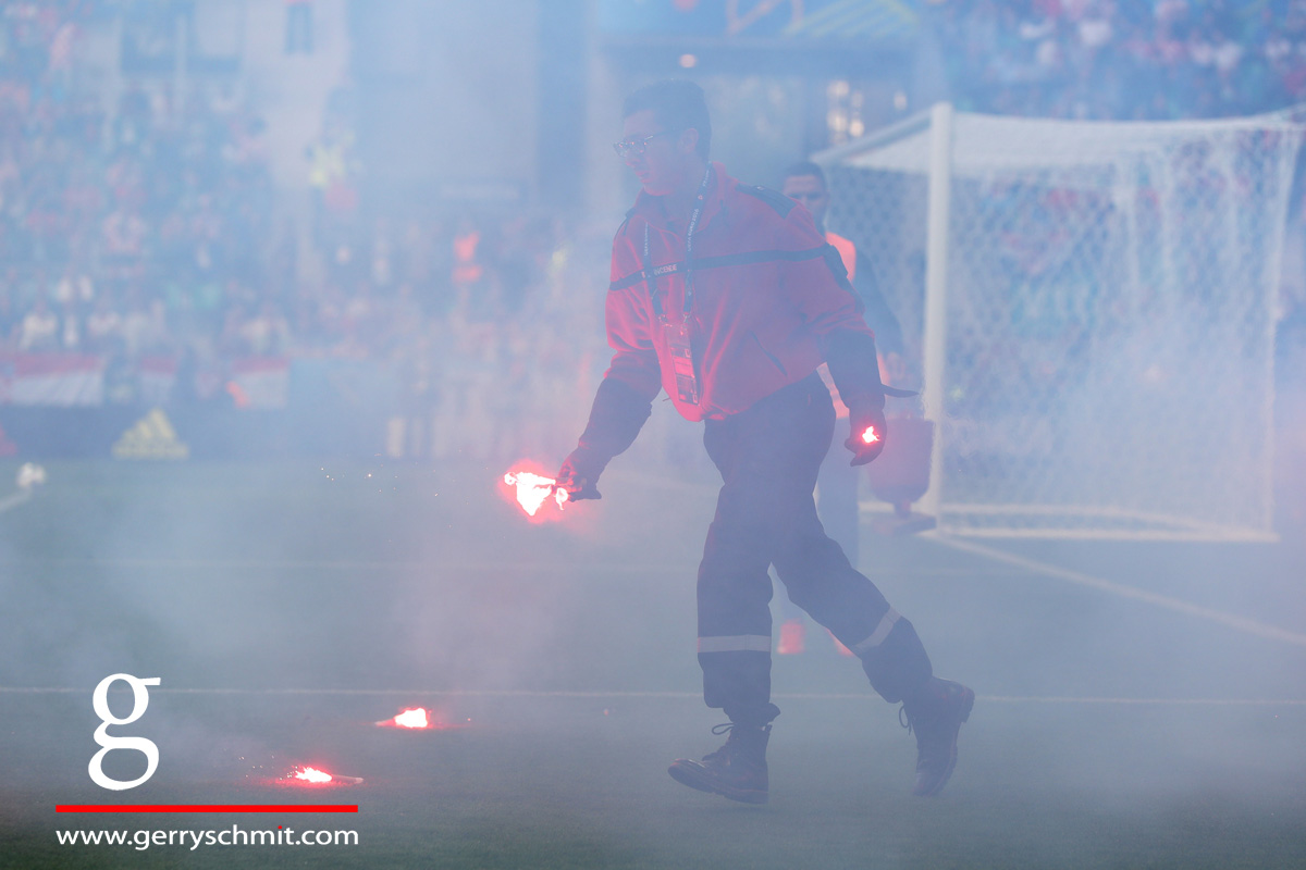 A Volunteer cleans of the pitch after Croatian fans threw pyro on the pitch